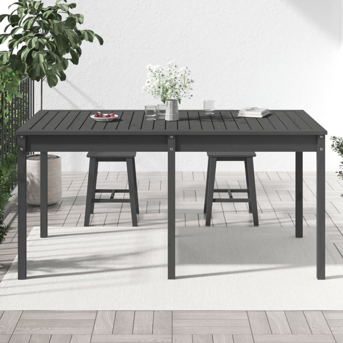 Essplatz im Freien mit Tisch, Hockern und Dekorationen. Der Tisch ist dunkelgrau.
