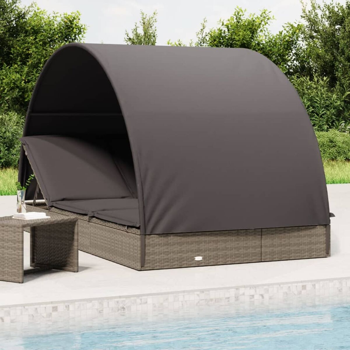 Graues Himmelbett neben einem kleinen Tisch. Pool im Hintergrund. Hellgraue Terrasse.