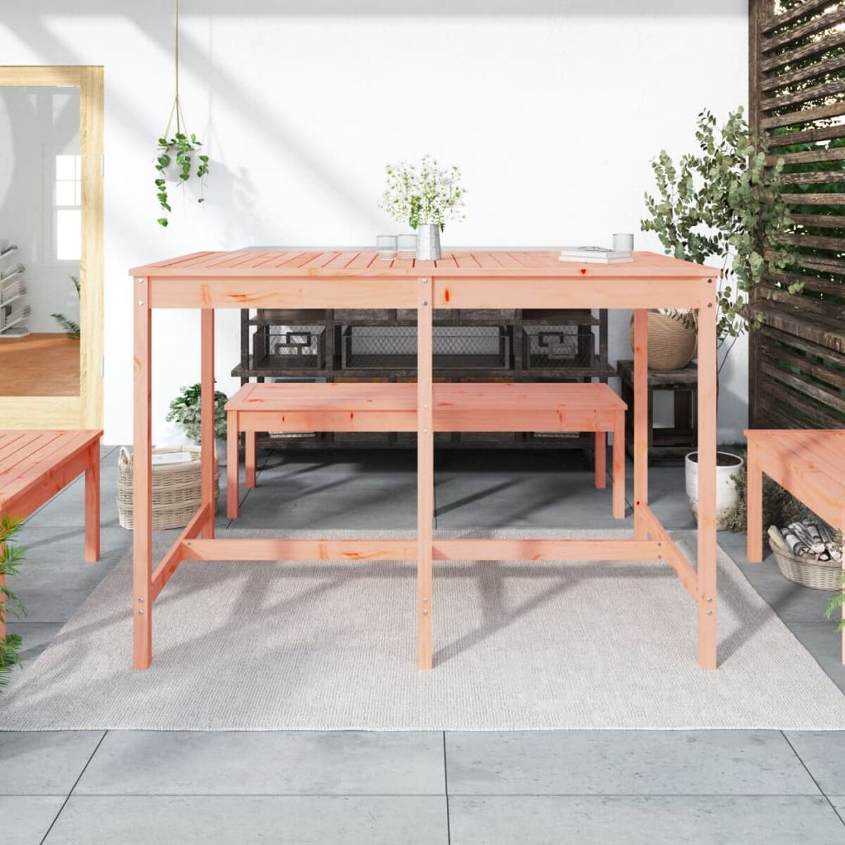 Eine Gruppe von Picknicktischen und -bänken, mit einem Tisch in der Mitte. Der Hintergrund ist eine Veranda.