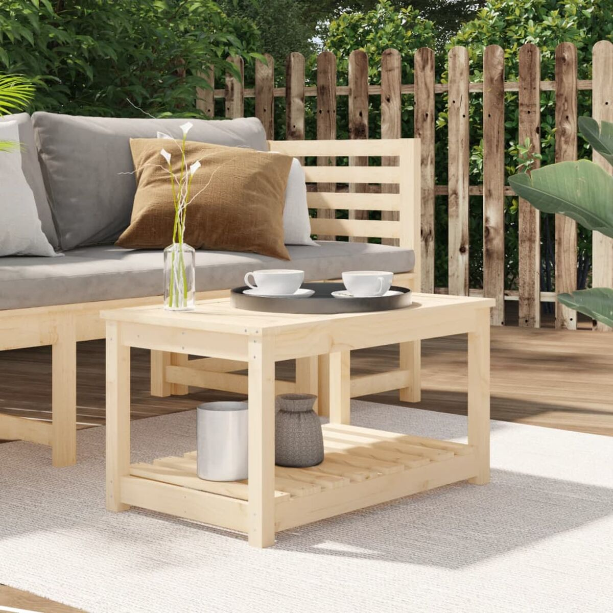 Holz-Couchtisch mit Tablett und Dekoration, umgeben von Gartenmöbeln.