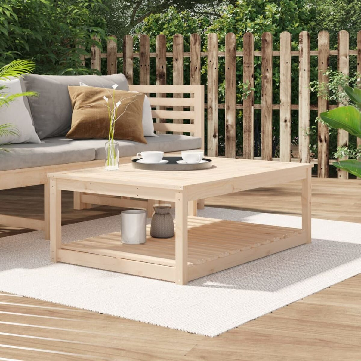 Couchtisch aus Holz auf einem Teppich. Mit Gegenständen oben und einem Regal unten. Szene im Freien.