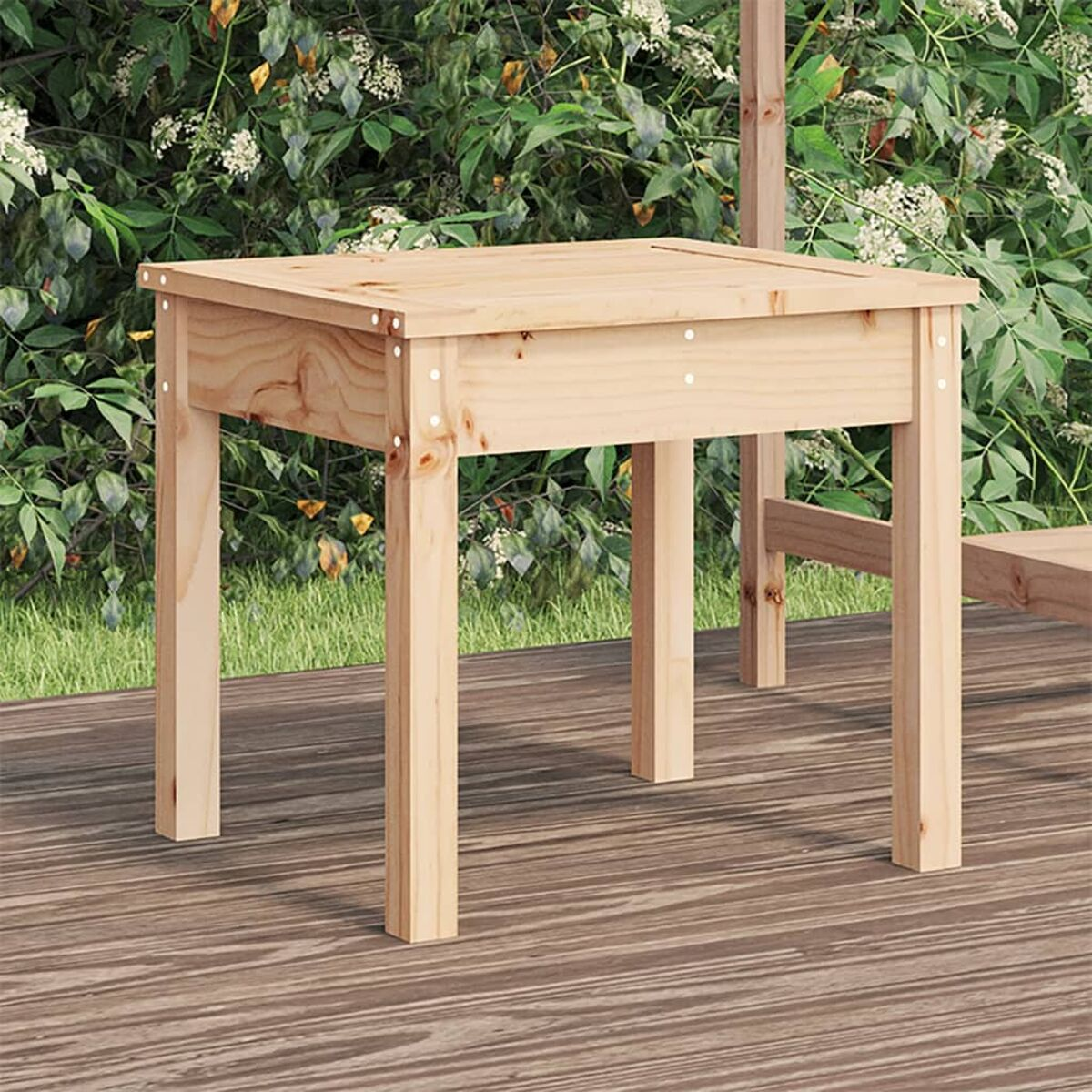 Holztisch mit Schrauben auf der Oberfläche, auf einem Holzdeck, vor einem Hintergrund aus Grün.
