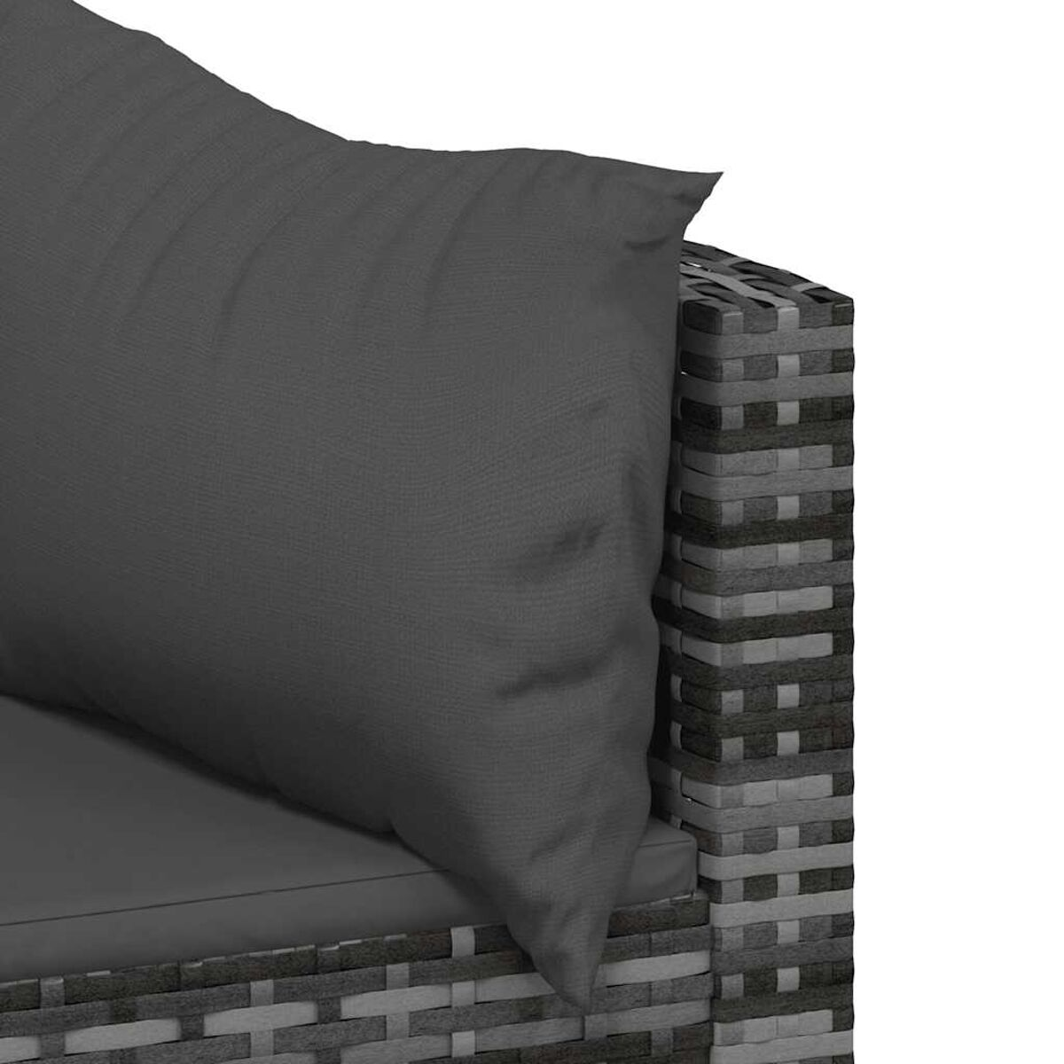 Nahaufnahme eines grauen Kissens auf einem Rattan-Sofa. Das Sofa ist braun.