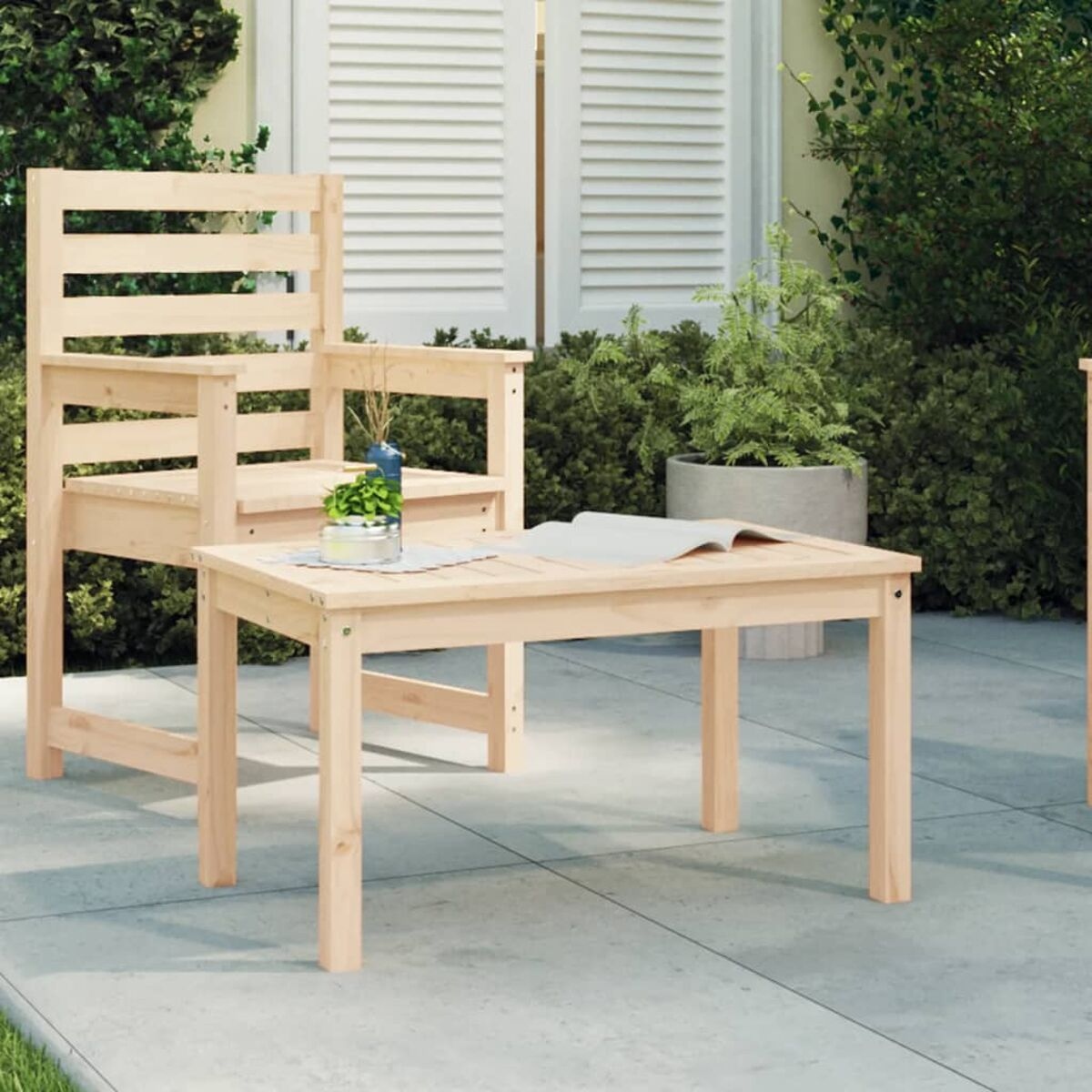 Holzstuhl und Tischset auf einer Terrasse. Hintergrund: Pflanzen und eine weiße Tür.