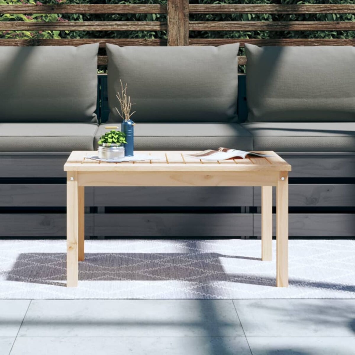 Holztisch mit Deko auf einer Terrasse.