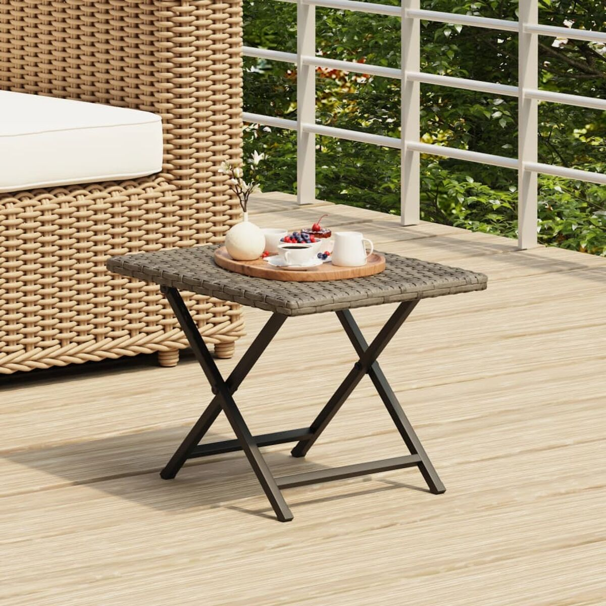 Kleiner grauer Tisch mit Tablett mit Gegenständen auf der Terrasse.