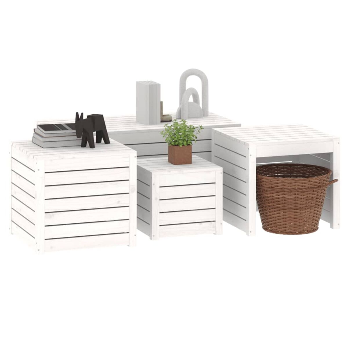 Ein Set aus weißen Holzquadern mit Dekorationsgegenständen und einem Weidenkorb.