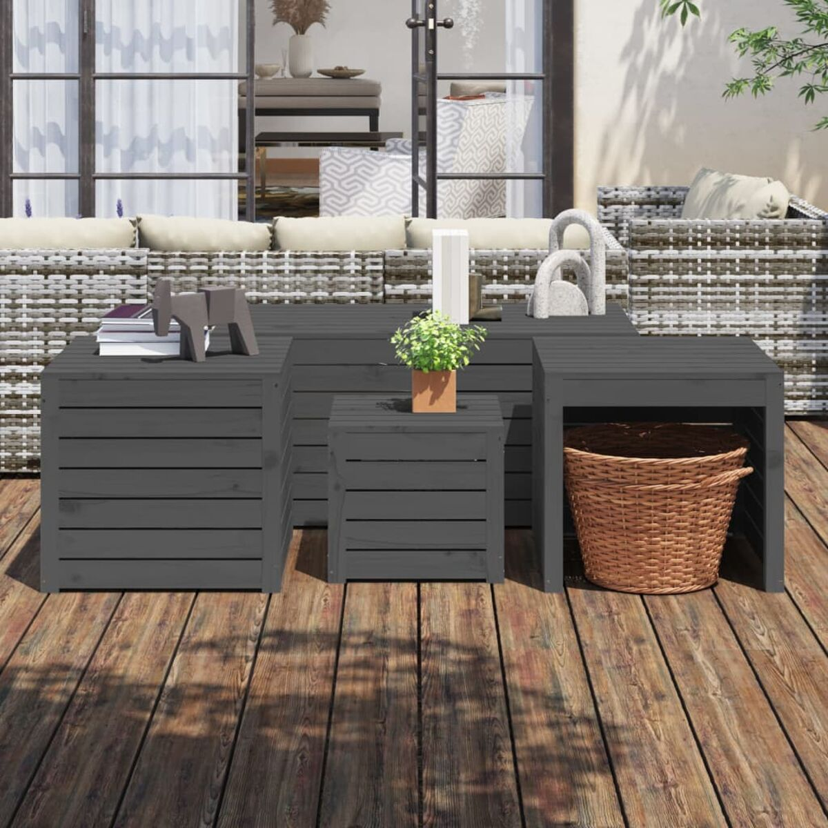 Graues Holzmöbel-Set im Freien mit Korb, Büchern und Dekorationen auf einem Deck.