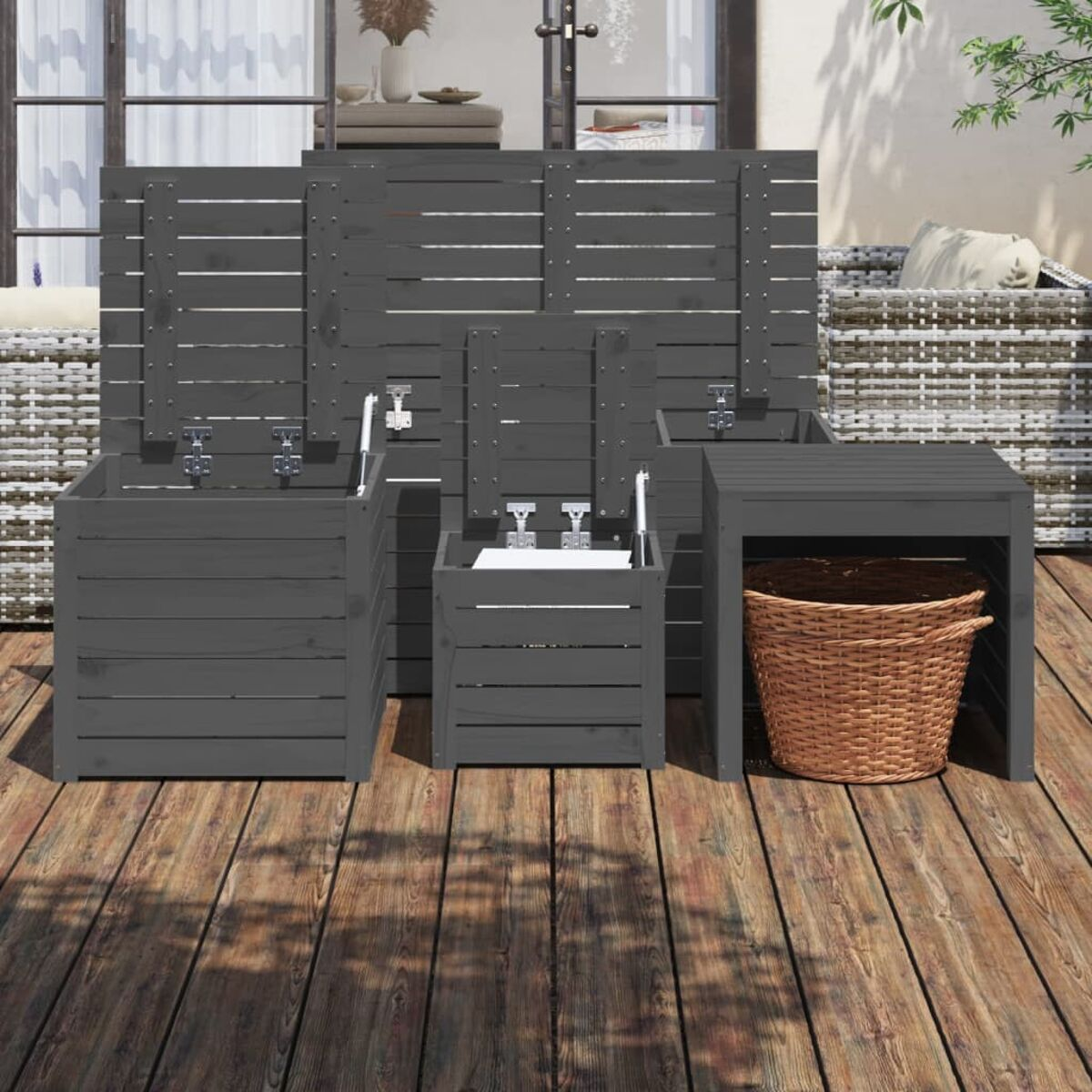 Outdoor-Aufbewahrungsset in Dunkelgrau: drei Boxen und ein kleiner Tisch auf Holzterrasse.
