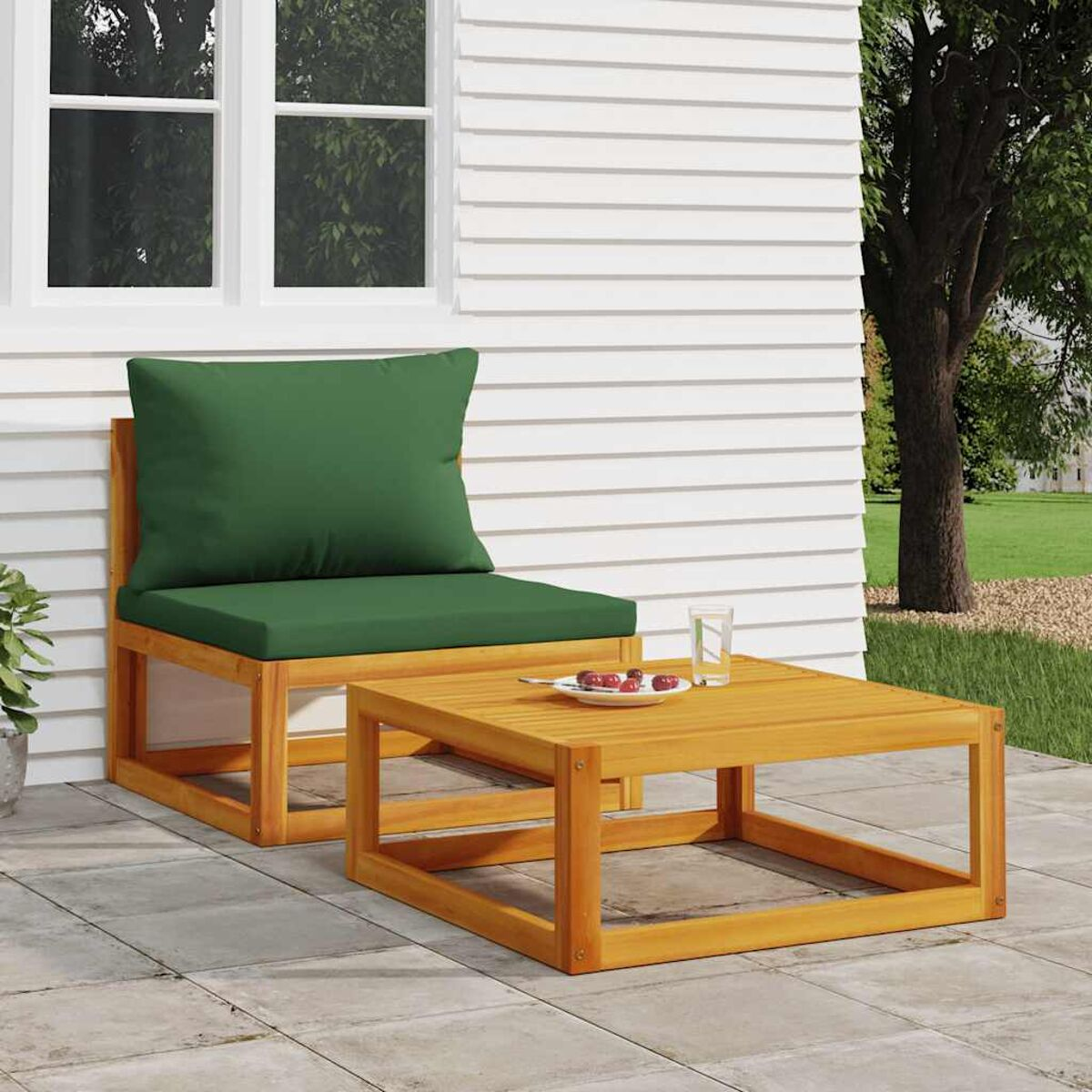 Ein Holzstuhl mit grünem Kissen und einem kleinen Tisch auf einer Terrasse.