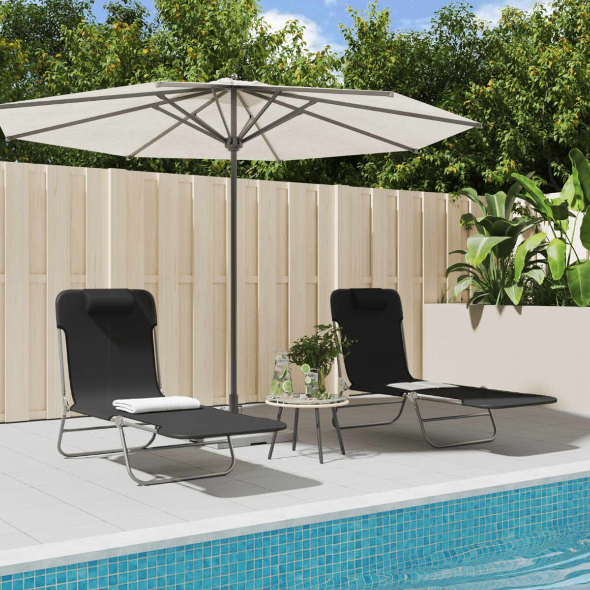 Zwei schwarze Sonnenliegen, kleiner Tisch und Sonnenschirm in der Nähe eines Pools.