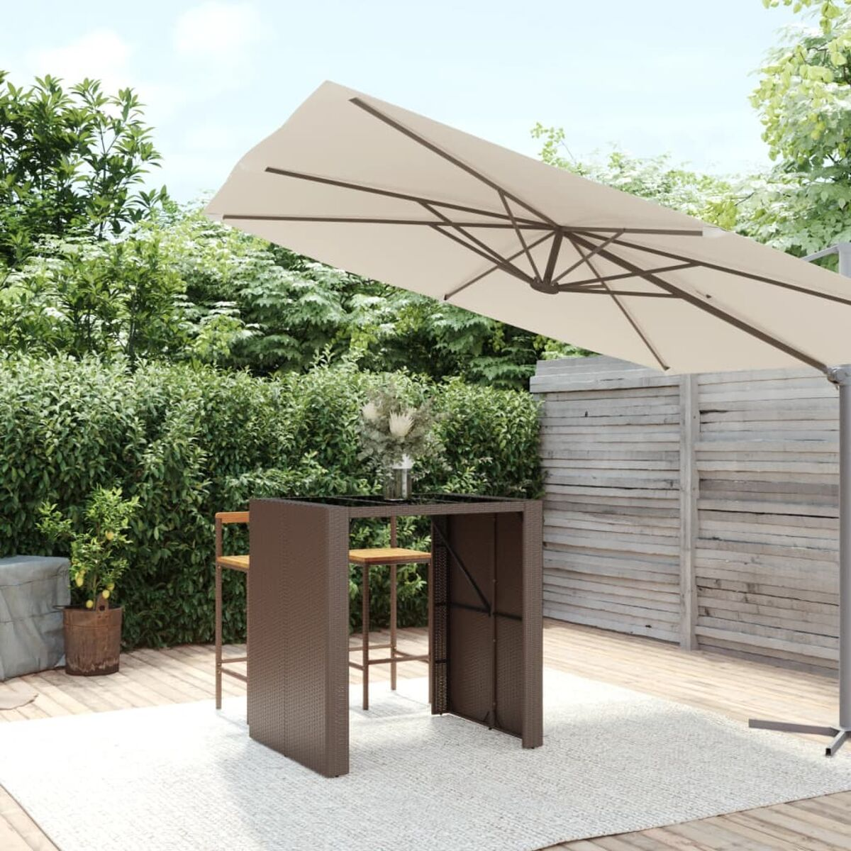 Outdoor-Setting mit Tisch und Sonnenschirm, umgeben von Grün.