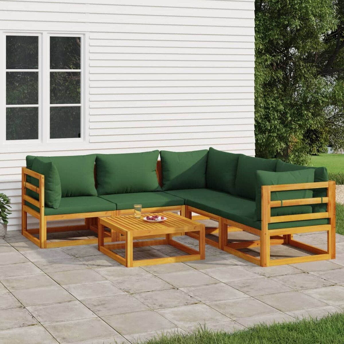 Sofa-Garnitur aus Holz im Freien mit grünen Kissen und einem quadratischen Couchtisch.