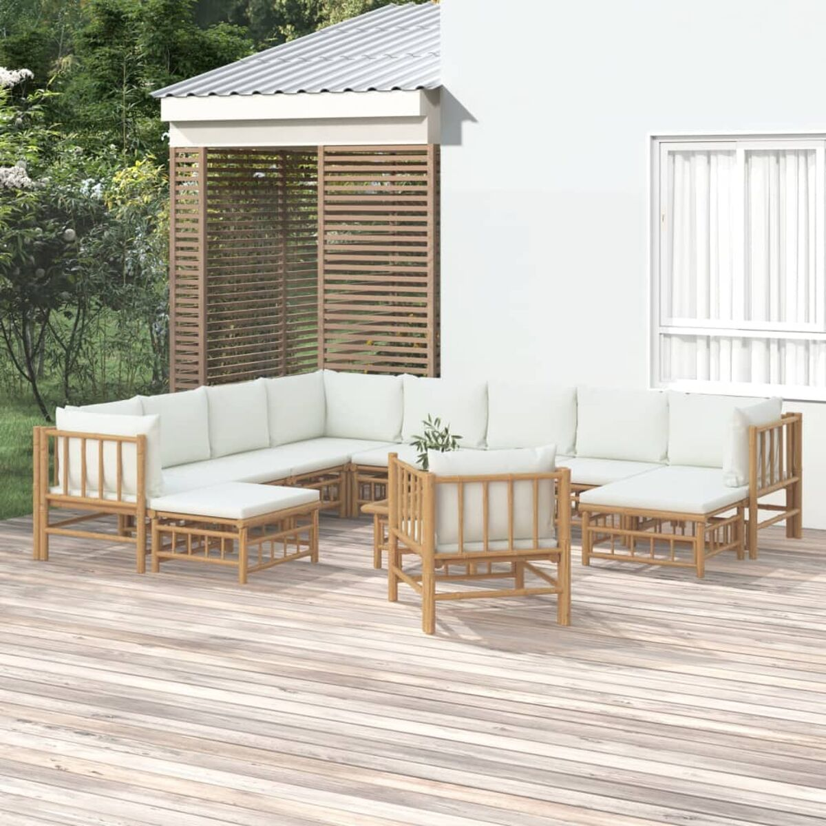 Garten-Ecksofa-Set aus Bambus mit weißen Kissen, einem kleinen Tisch und einem Holzdeck.