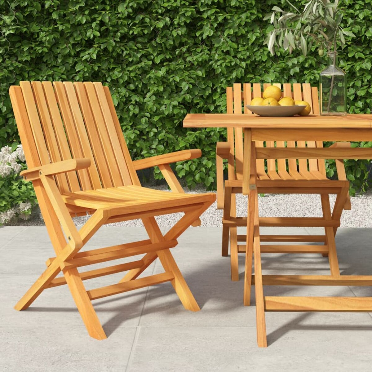 Gartenmöbel-Set aus Holz auf einer Terrasse, mit Hecke im Hintergrund.
