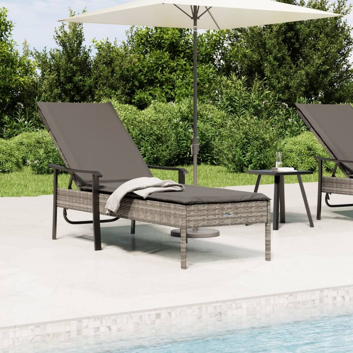 Eine Liege mit Beistelltisch und Sonnenschirm. Im Hintergrund befindet sich ein Pool.