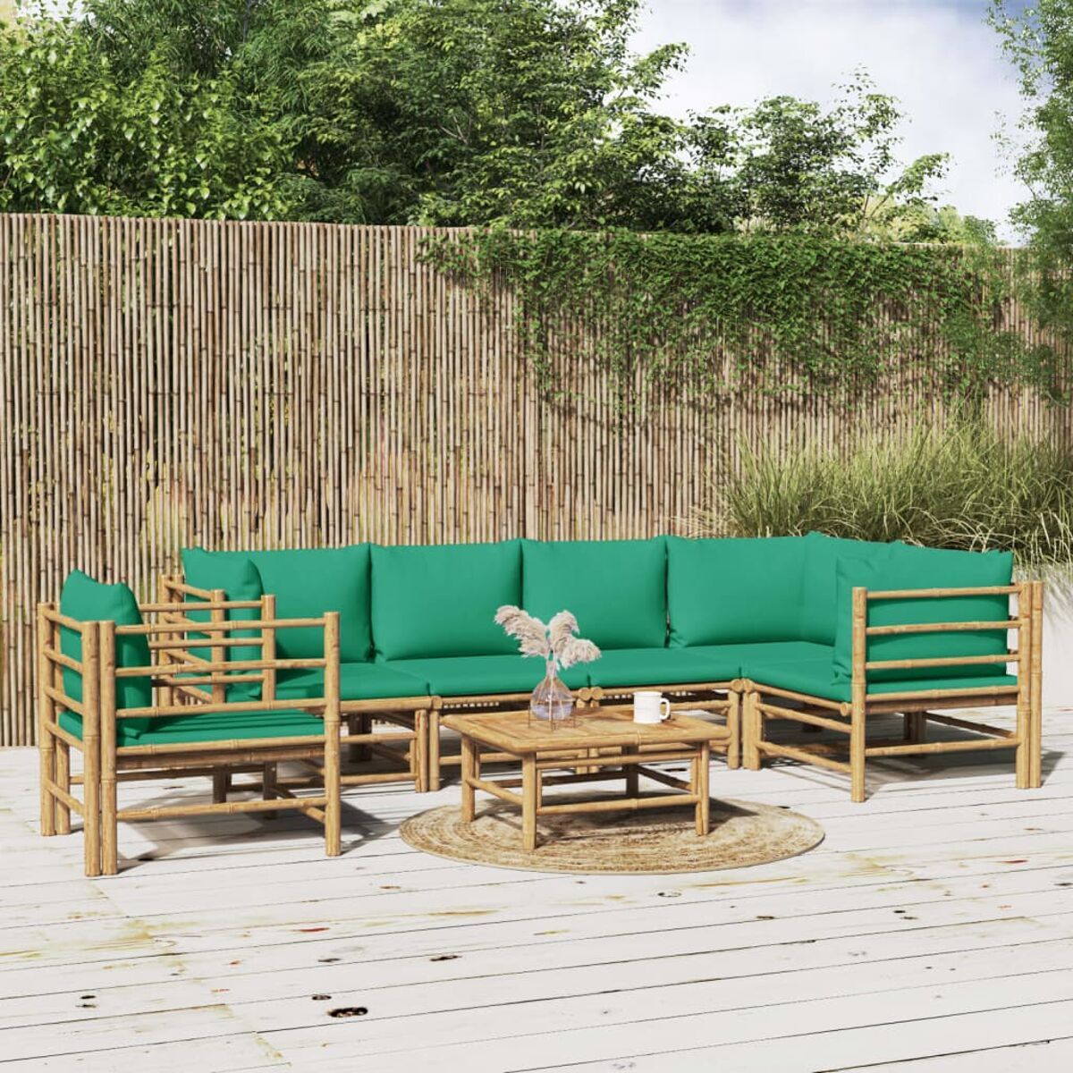 Outdoor-Bambusmöbel-Set mit grünen Kissen. Enthält ein Sofa, einen Tisch und Bambuszäune.