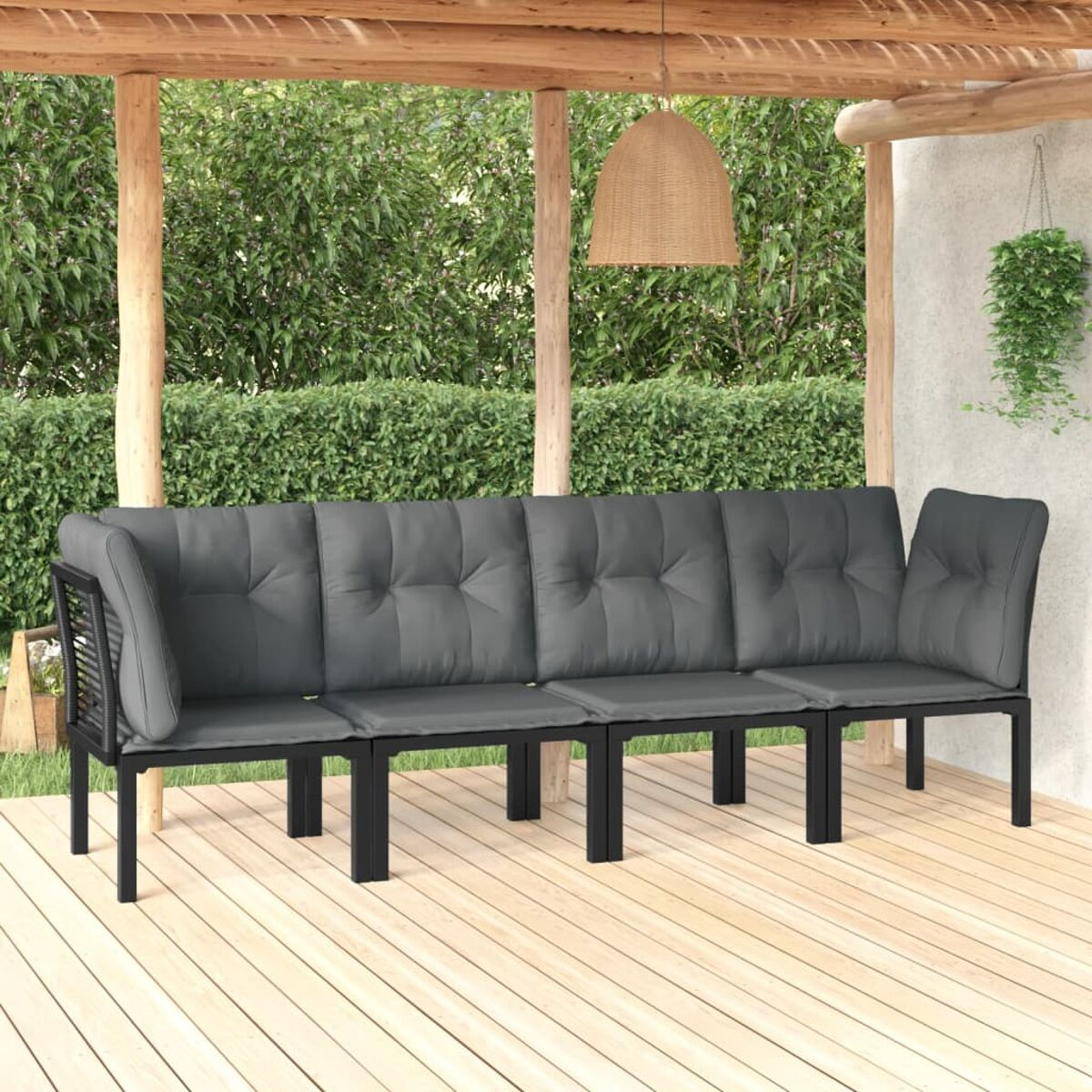 Graues Outdoor-Sofa mit Kissen auf einer Holzterrasse. Grüner Hintergrund.