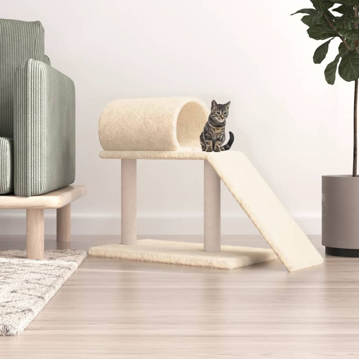 Eine getigerte Katze sitzt auf einem beigen Katzenbaum mit Tunnel und Rampe. Sofa und Pflanze.