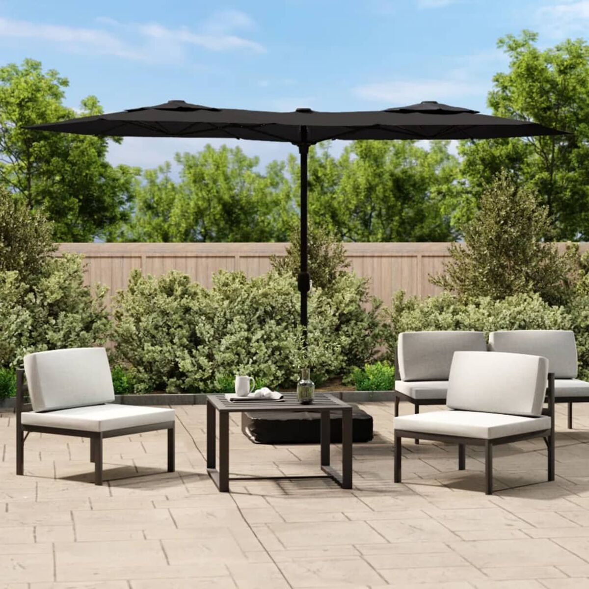 Terrassenaufbau mit Sitzgelegenheiten, einem Tisch und einem großen Doppel-Sonnenschirm an einem sonnigen Tag.