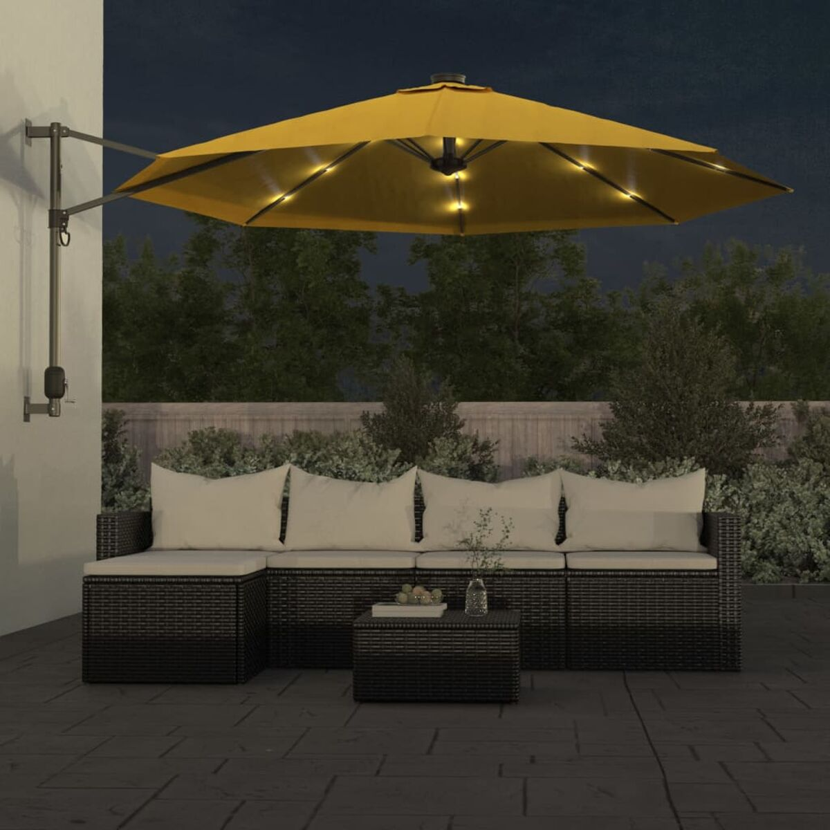 Terrassenset im Freien bei Nacht. Enthält ein Sofa, einen kleinen Tisch und einen gelben Schirm mit Lichtern.