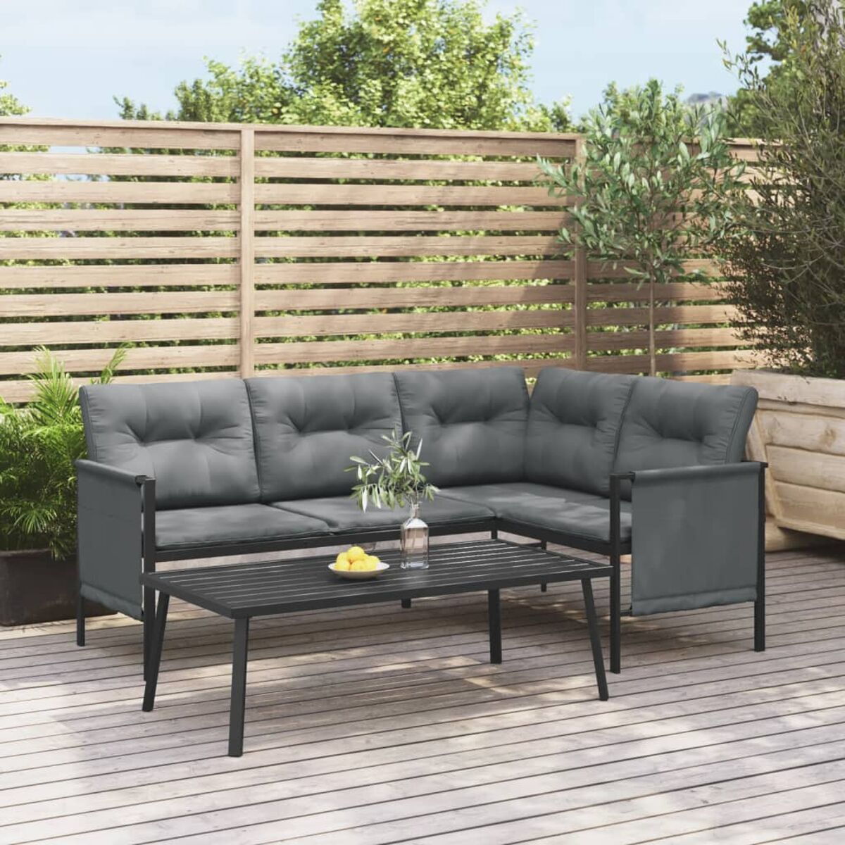 Outdoor-Ecksofa mit Couchtisch auf Holzterrasse. Graue Kissen.
