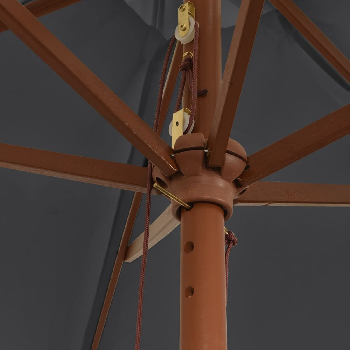 Nahaufnahme des Mechanismus eines Regenschirms. Es zeigt Holz, Metallteile und ein Seil.