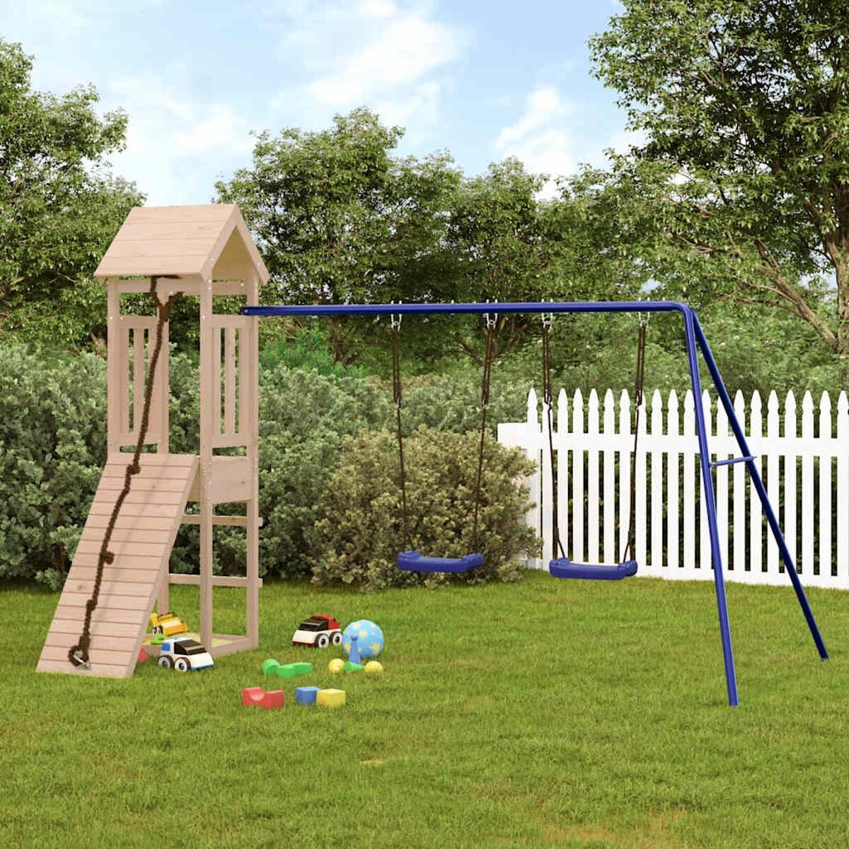 Spielplatz aus Holz, Rutsche, Schaukeln und Kletterseil auf einer Rasenfläche mit Bäumen und weißem Zaun.