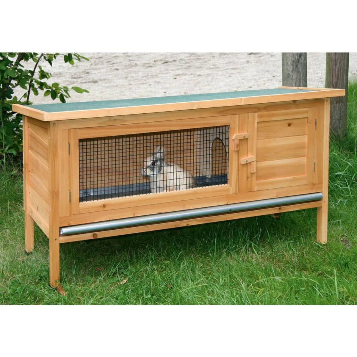 Kaninchenstall aus Holz. Ein weißes Kaninchen ist darin. Es hat eine Gitterfront und eine Tür.