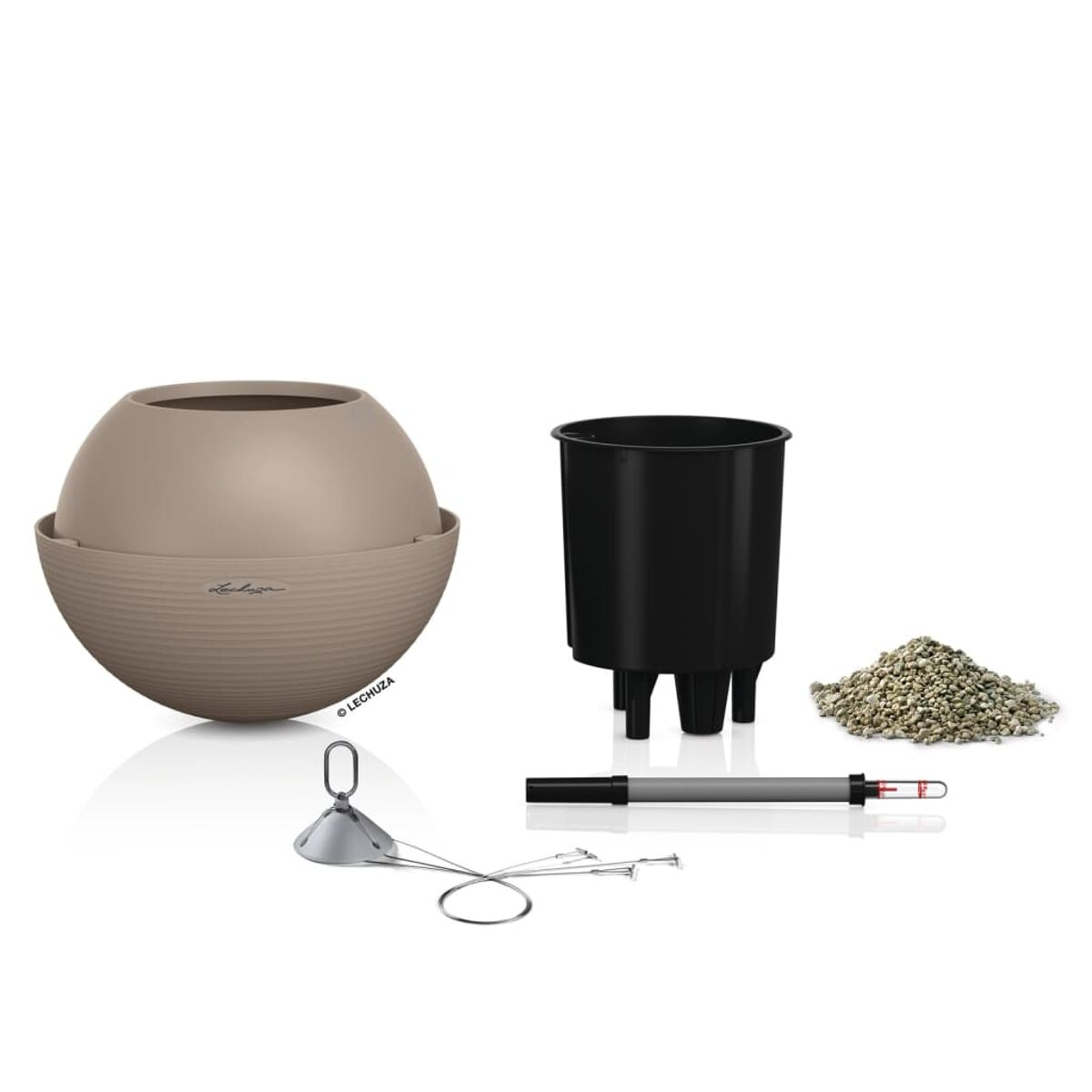 Une jardinière ronde beige avec un pot intérieur noir, des accessoires et un tas de galets.