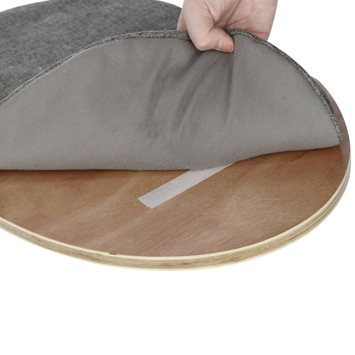 Ein grauer Kissenbezug wird angehoben, um ein Holzbrett freizulegen.