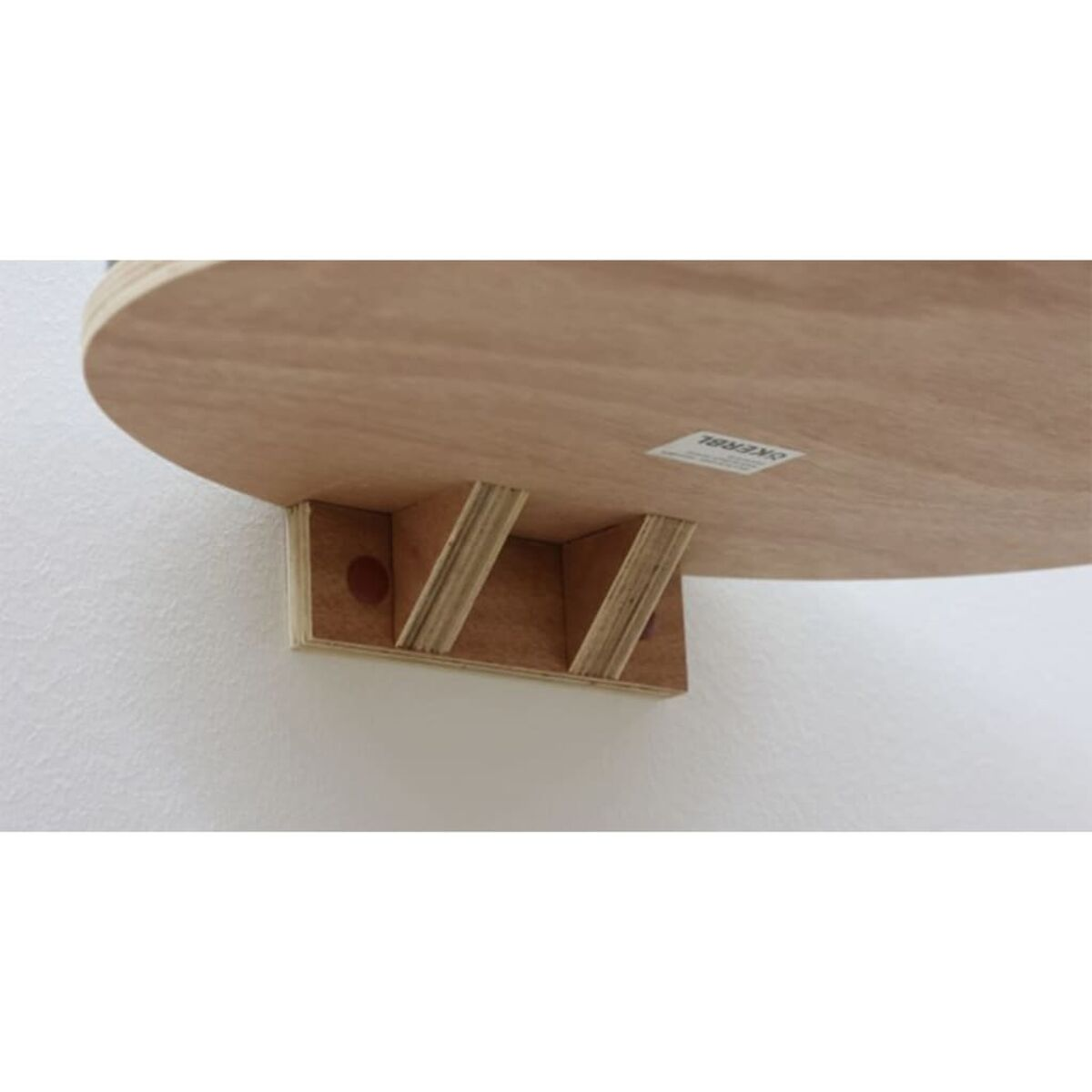 Holzregal an einer weißen Wand befestigt. Das Regal hat eine gebogene Form und eine Tragstruktur.