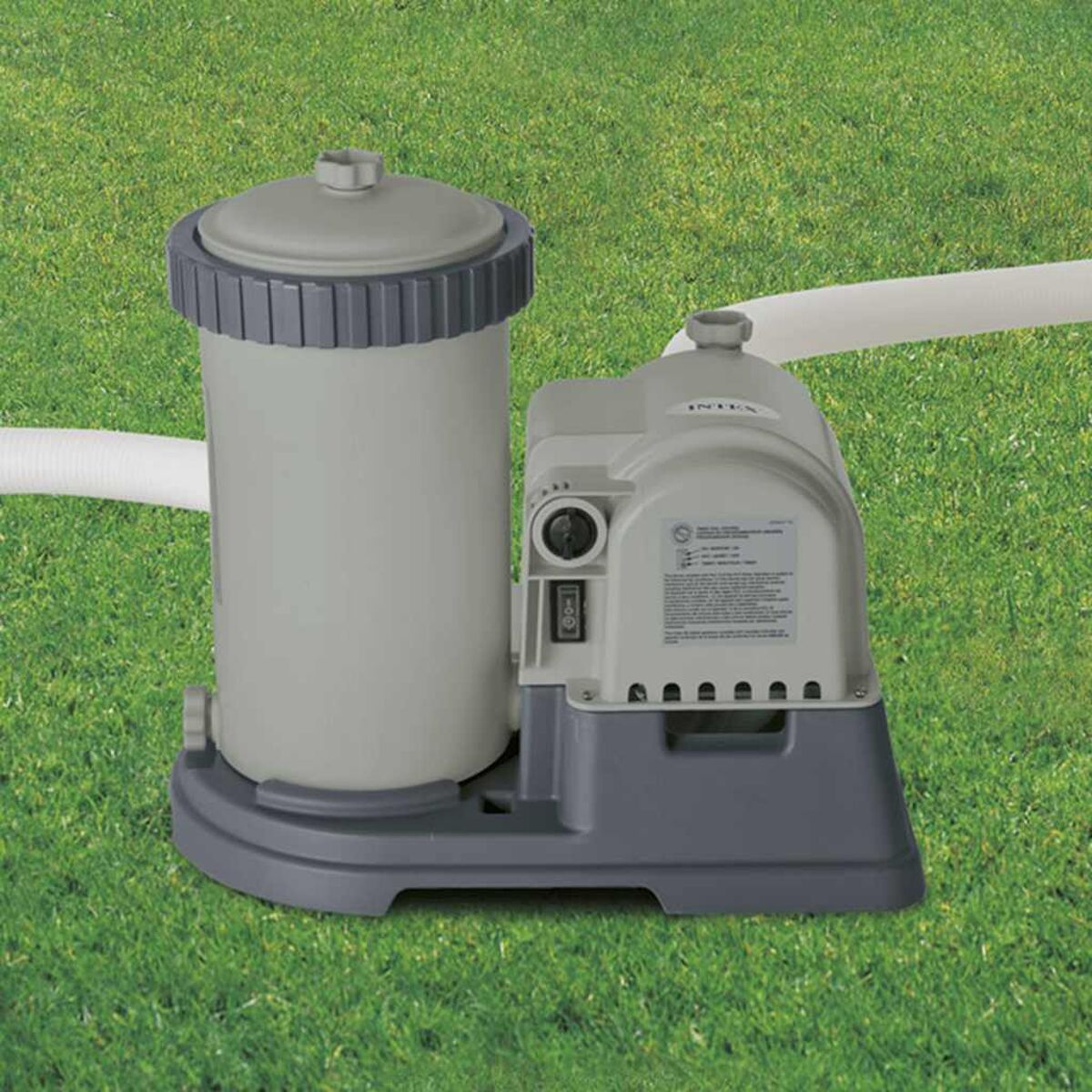 Poolfilter und Pumpe auf grünem Gras, mit Schläuchen.