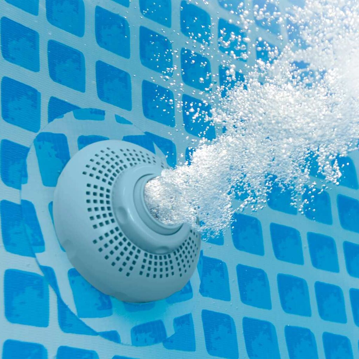 Eine weiße Pool-Düse mit Wasserblasen, die aus einem blau gefliesten Pool austreten.