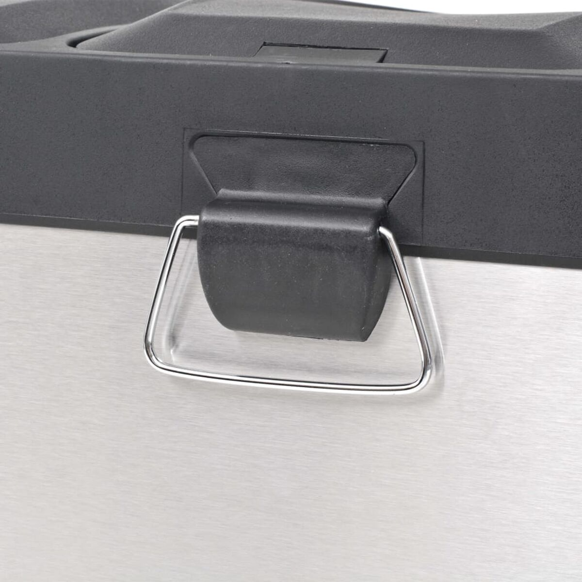 Ein Metallgriff an einem schwarz-silbernen Behälter. Der Griff ist silberfarben.