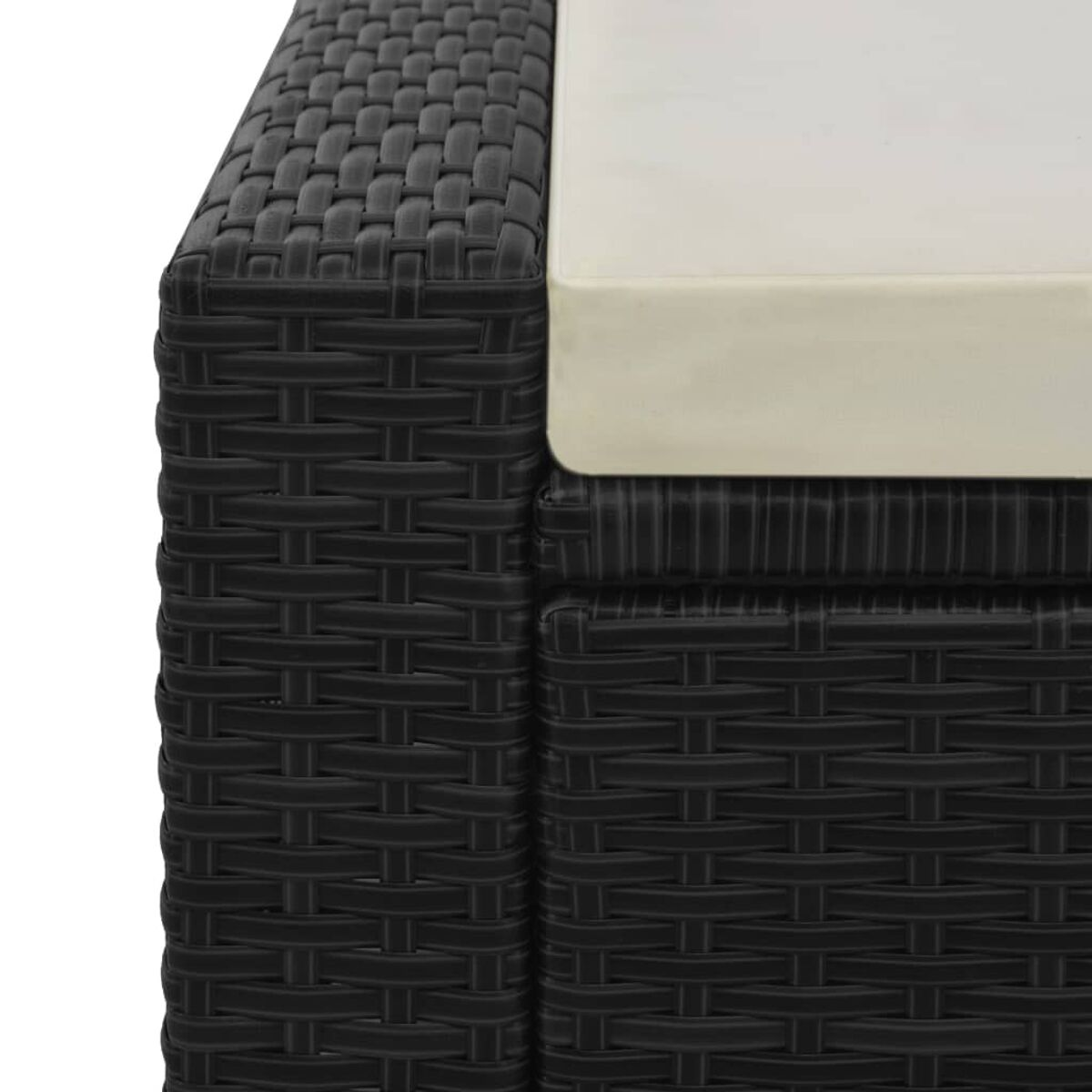 Nahaufnahme einer schwarzen gewebten Wicker-Ecke mit einem cremefarbenen Kissen.