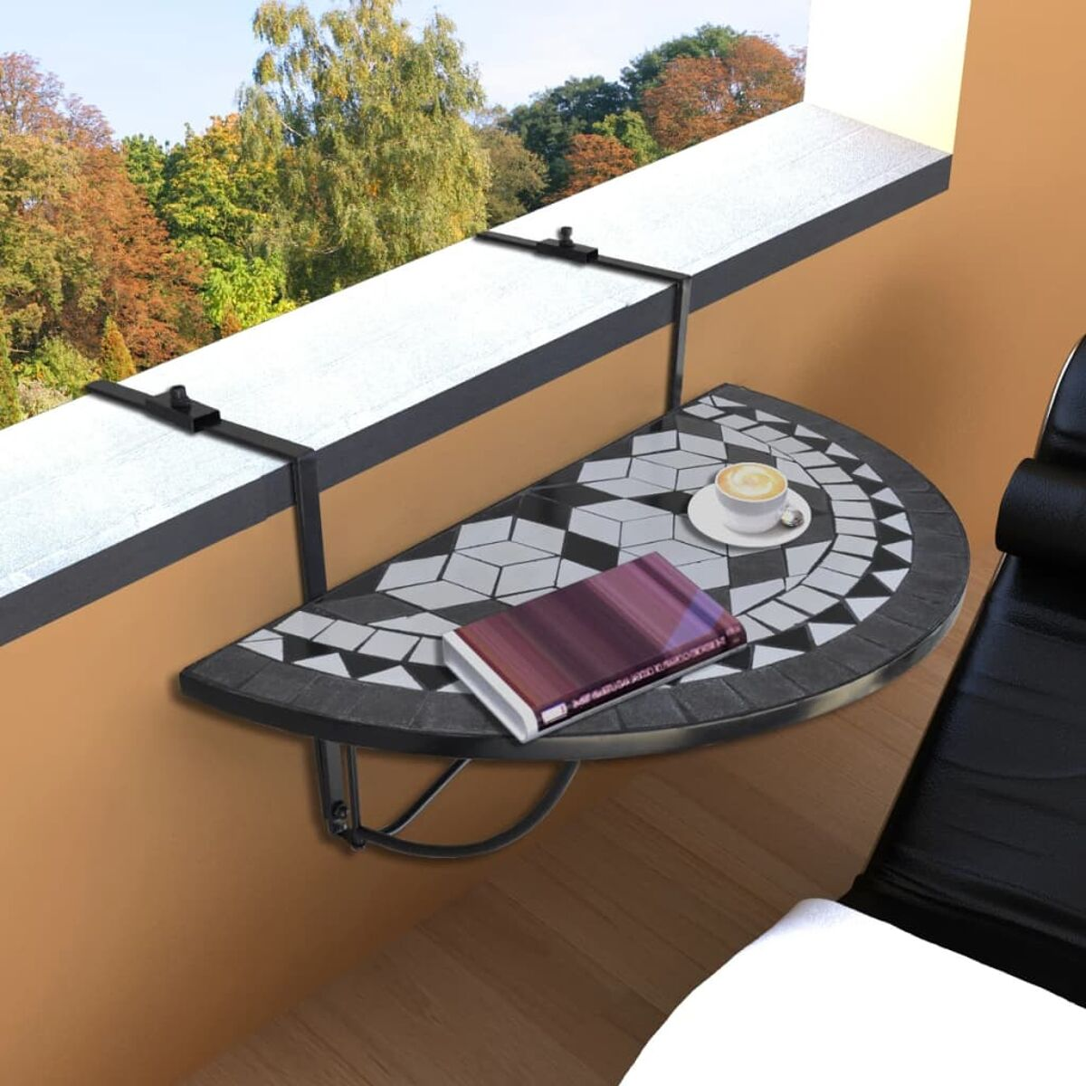 Balkontisch, Halbkreis, Mosaikfliesenplatte. Buch und Kaffeetasse darauf. Schwarzer Metallrahmen.