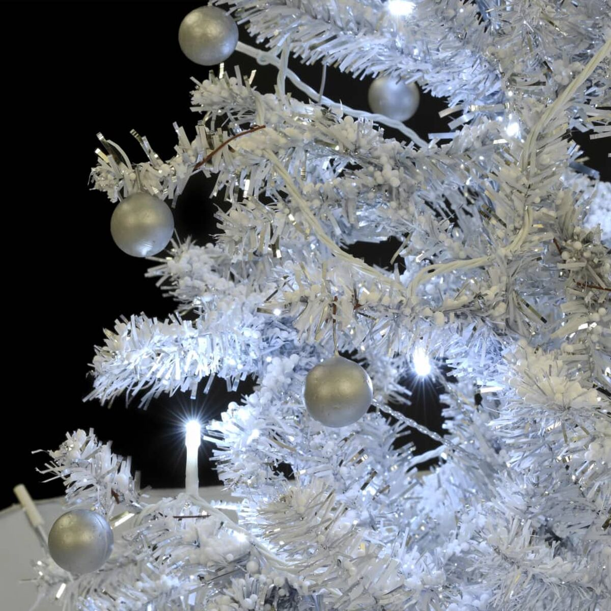 Weihnachtsbaum mit silbernen Ornamenten und Lichtern.