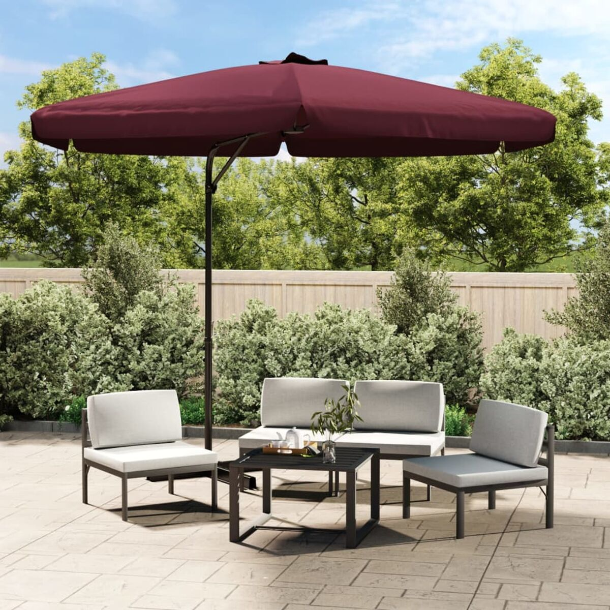 Terrassenset mit einem weinroten Schirm, vier grauen Stühlen und einem schwarzen Tisch.