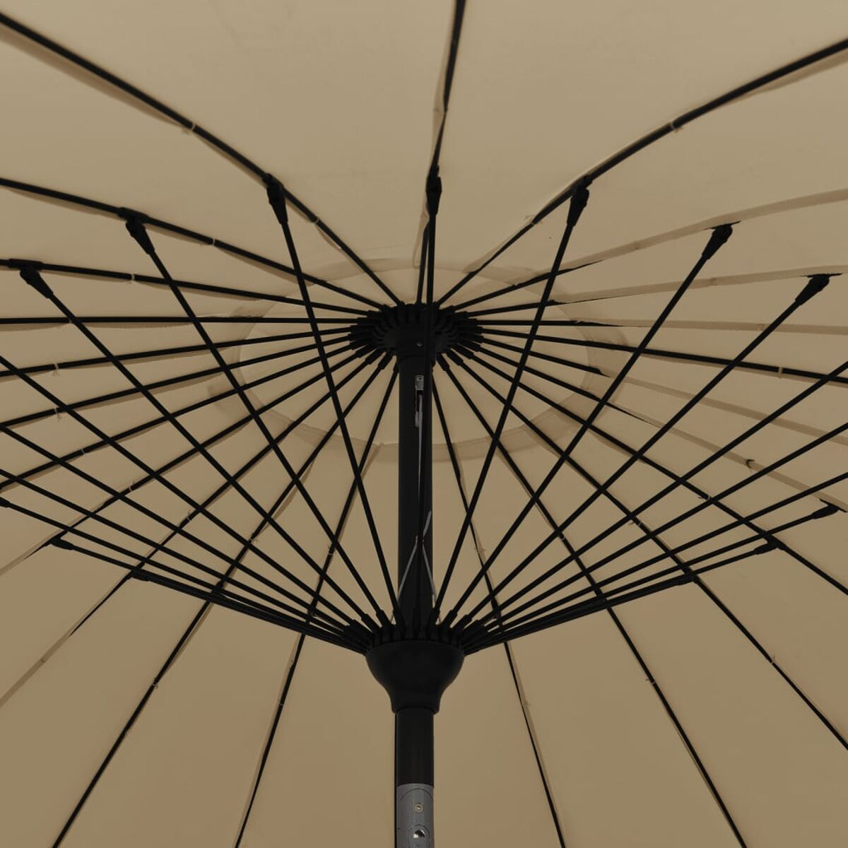 Nahaufnahme des Inneren eines beigen Regenschirms. Schwarze Metallrippen strahlen vom Zentrum aus.