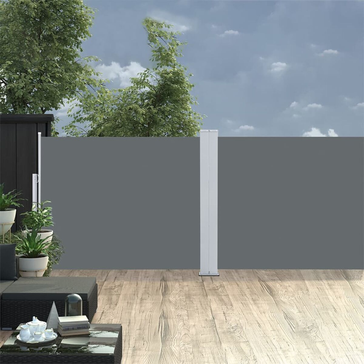 Szene im Freien mit grauem Sichtschutz, Holzterrasse und Pflanzen. Himmel im Hintergrund.