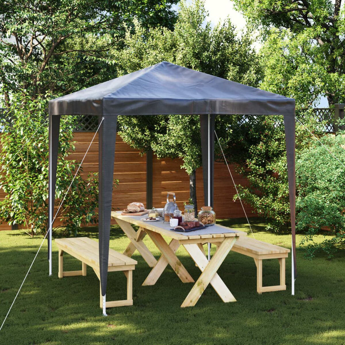 Pavillon in einem Garten mit Tisch, Bänken und Essen. Grünes Gras.