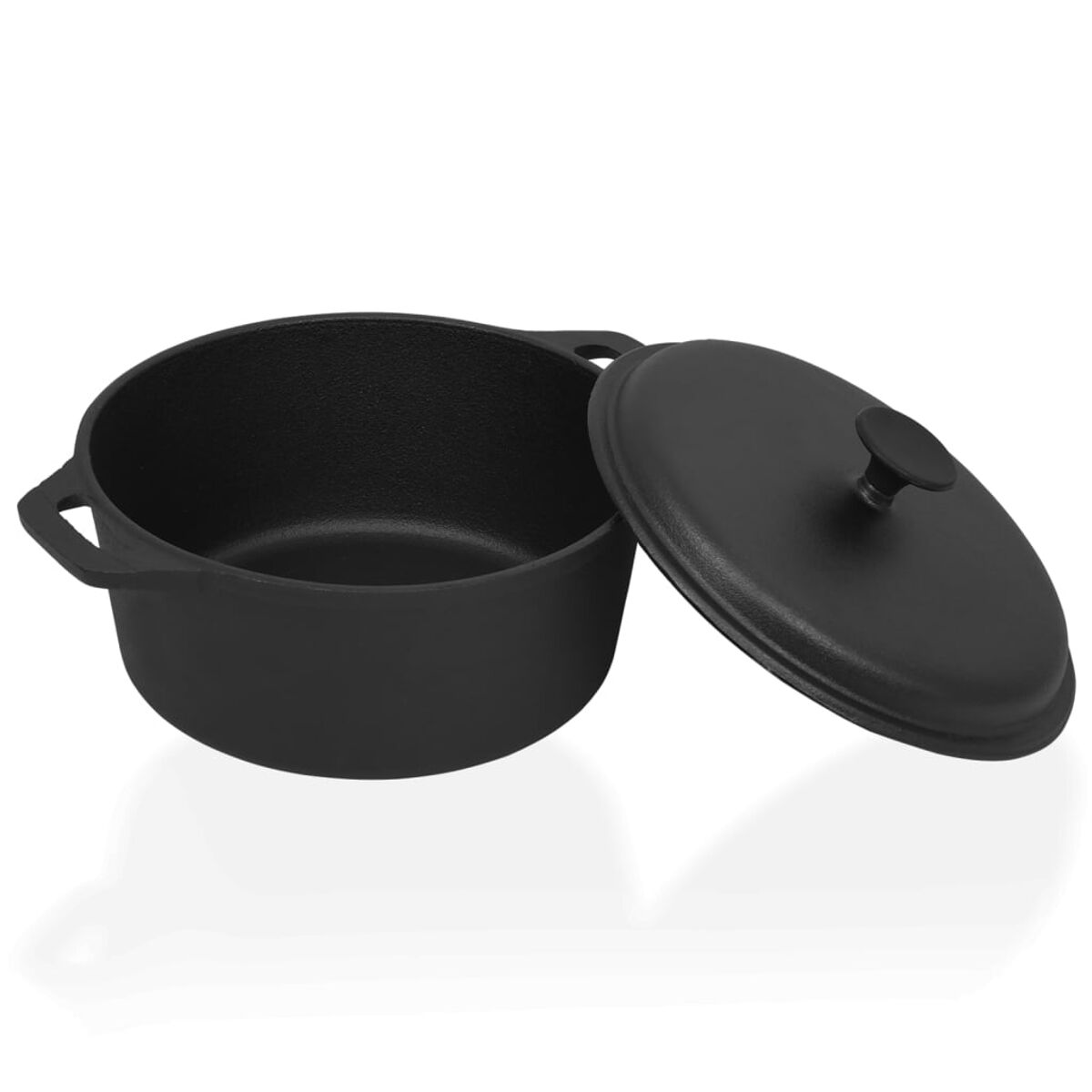 Olla de hierro fundido negro con tapa. Olla abierta. Tapa a un lado.