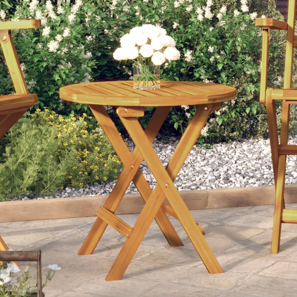 Klapptisch aus Holz mit einer Vase weißer Blumen. Es ist draußen.