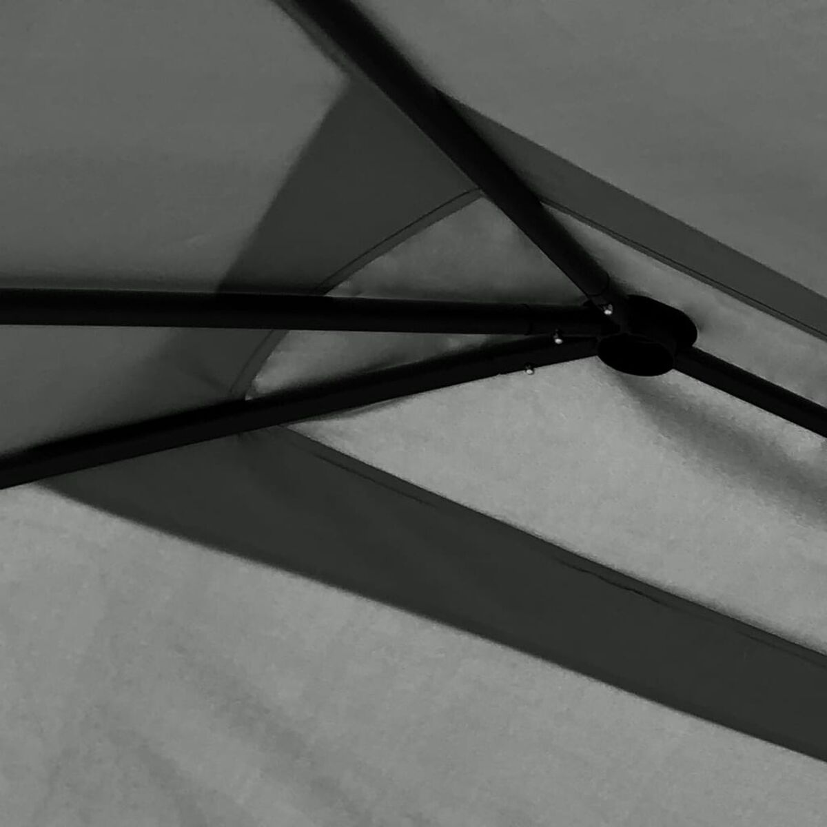 Nahaufnahme des Inneren eines grauen Zeltes. Dunkle Metallstützen und grauer Stoff.