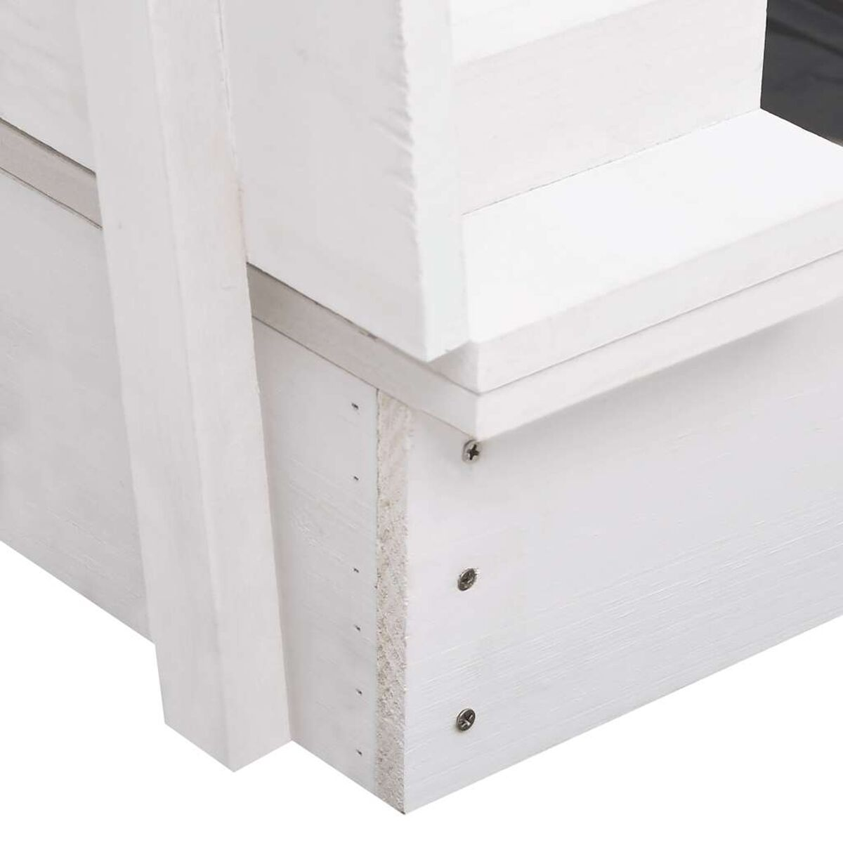 Primo piano di una struttura in legno verniciata di bianco, che mostra i dettagli del giunto angolare.