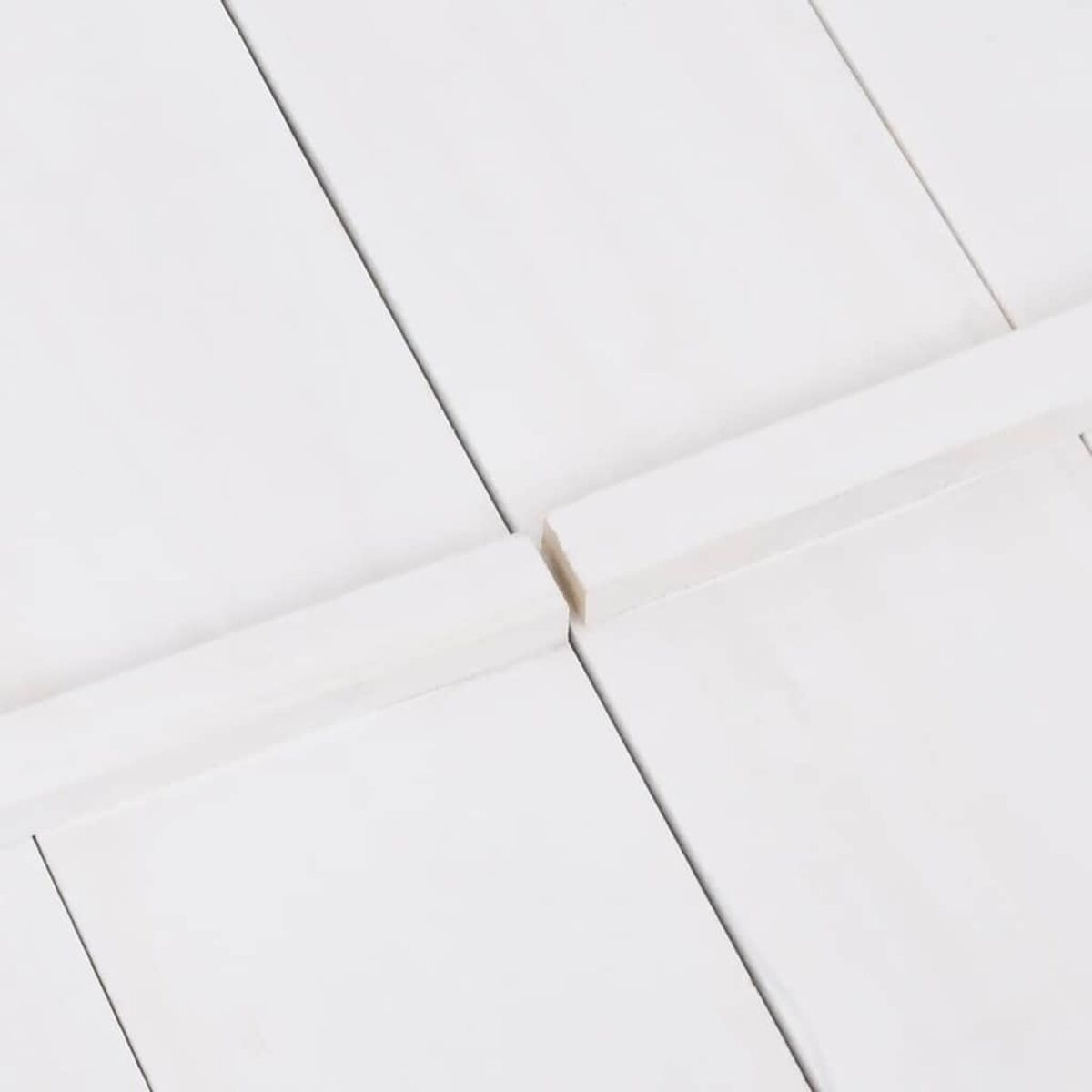 Tavole di legno bianche, unite. Le linee creano un motivo.