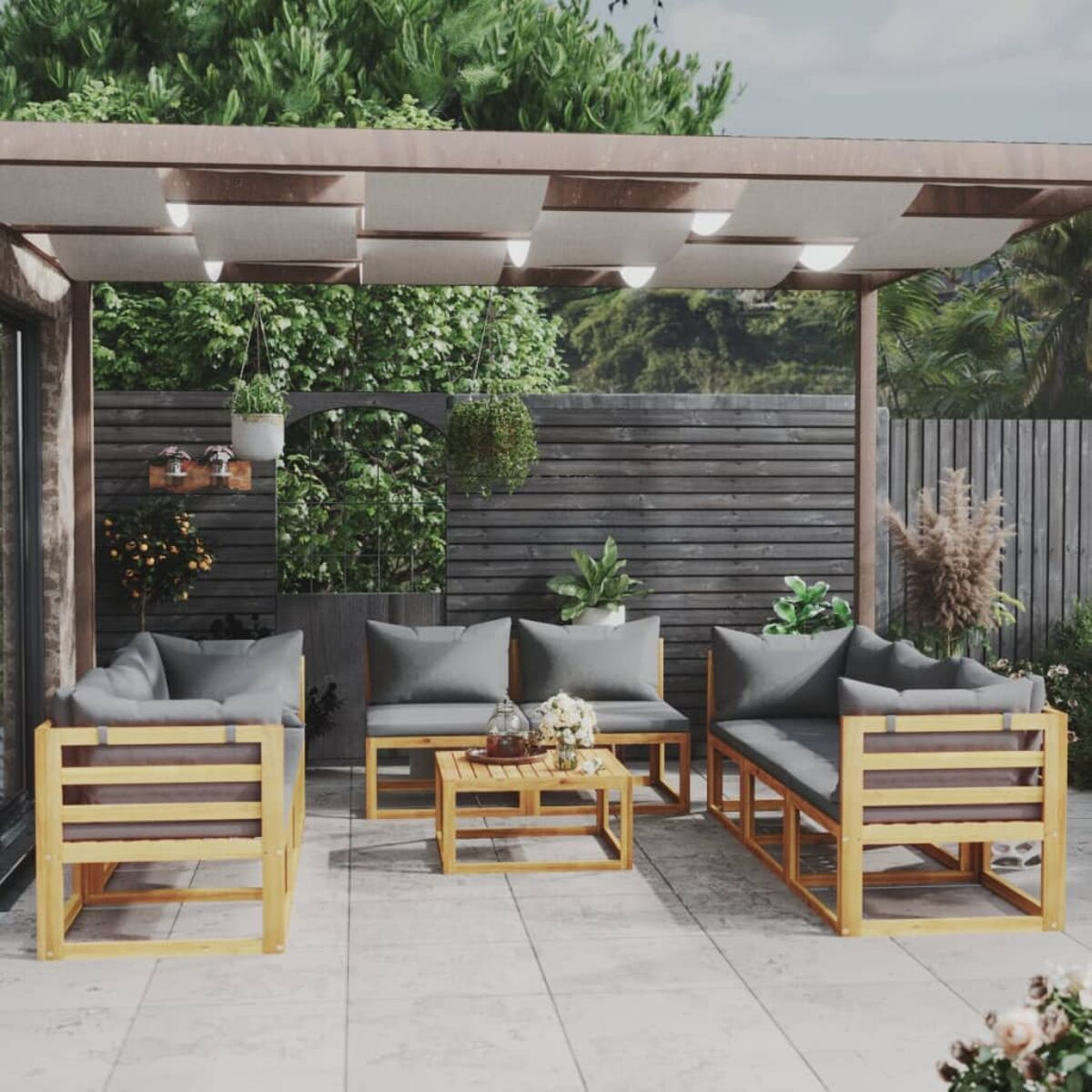 Sitzbereich im Freien mit Pergola, Möbeln, Pflanzen und Lichtern auf einer Steinterrasse.