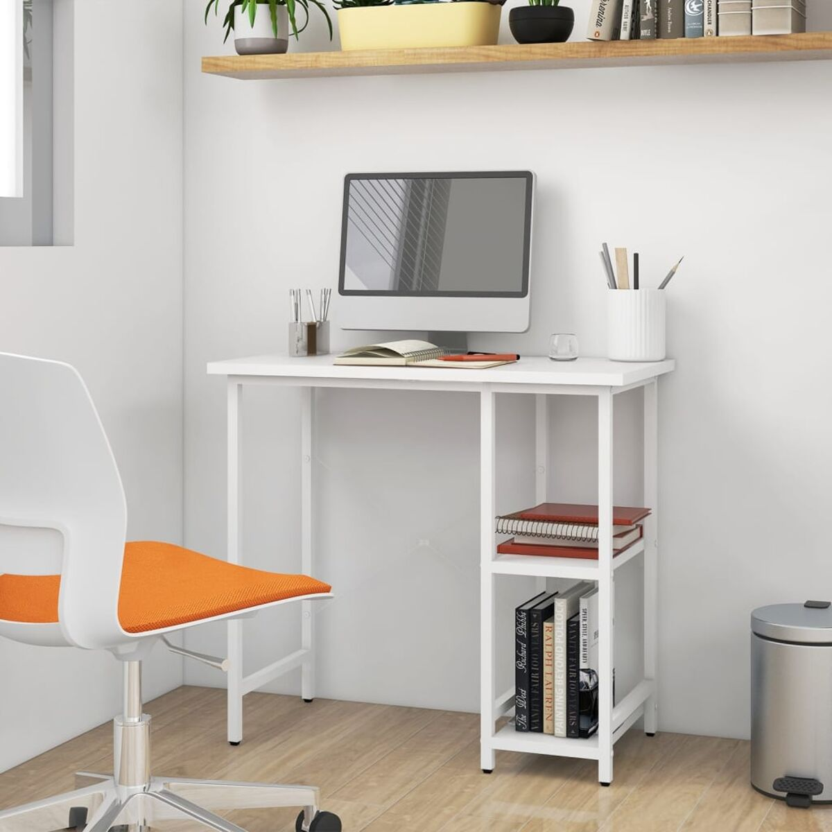 Weißer Schreibtisch mit Computer. Stuhl, Bücherregal und Mülleimer im Raum. Weiße Wand.