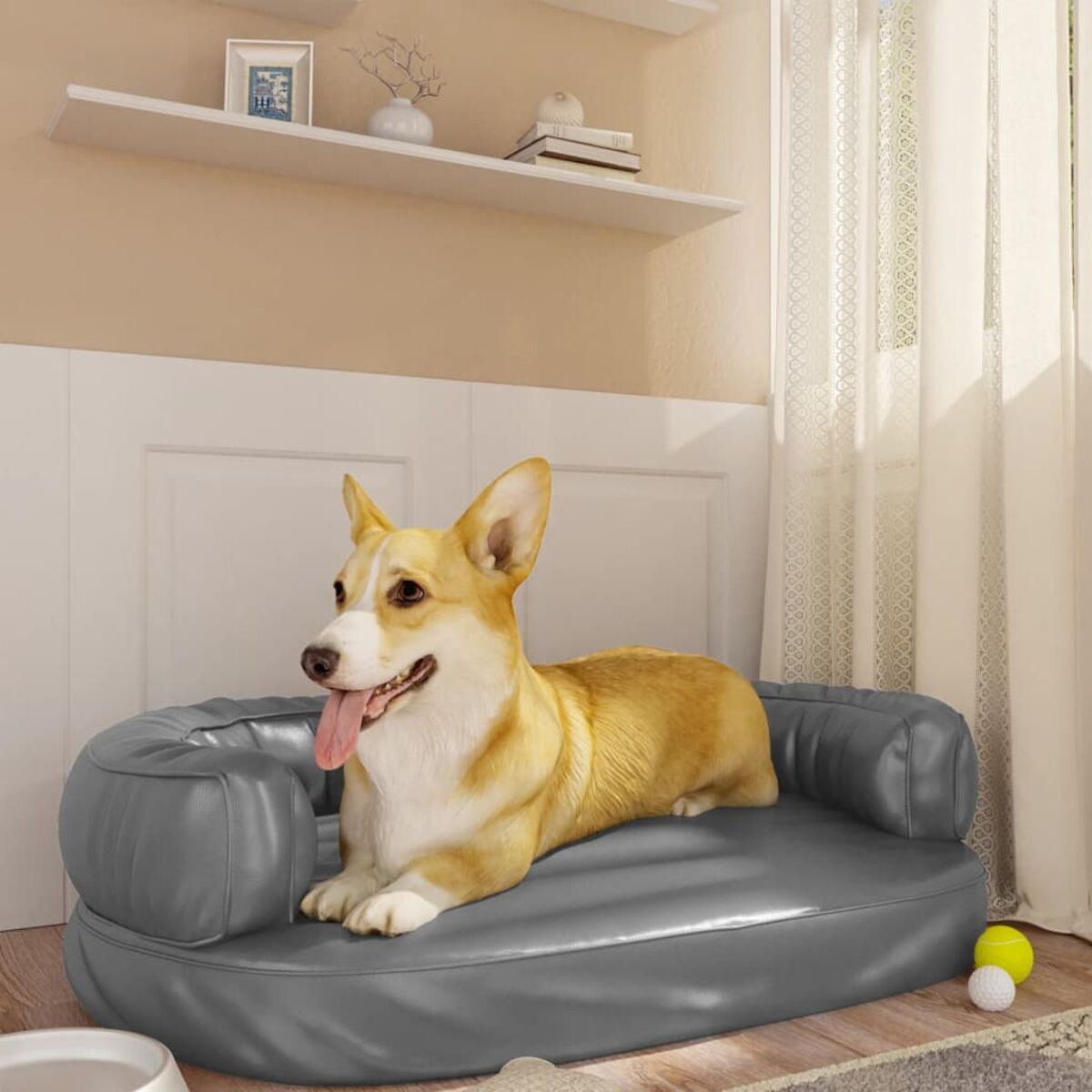 Ein Corgi-Hund ruht auf einem grauen Hundebett. Im Hintergrund ein Regal und ein Fenster.